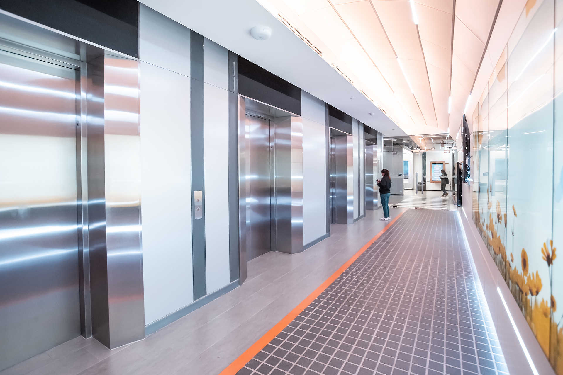 A focused technician troubleshooting an elevator's red control board with LED indicators.